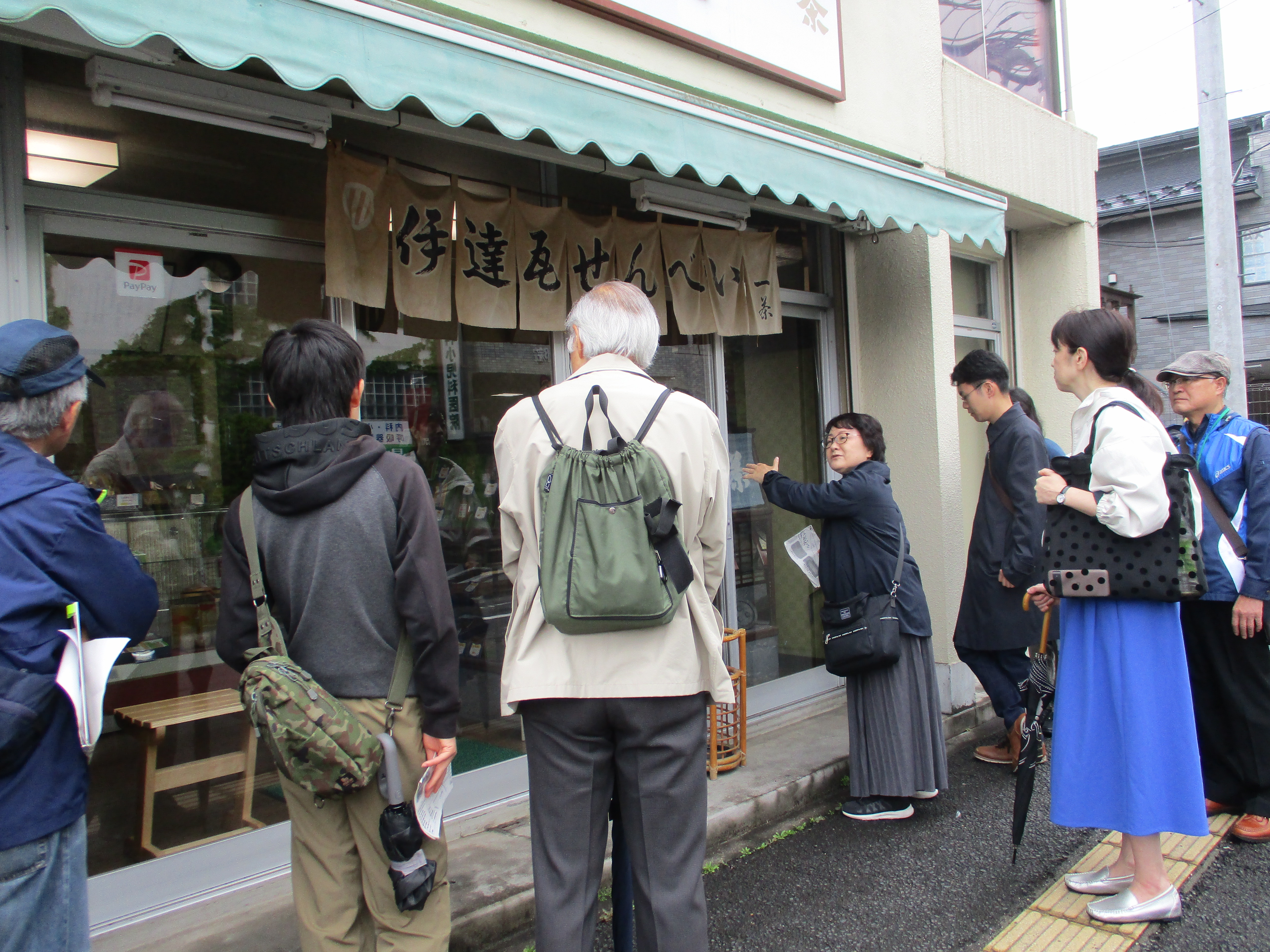 伊達瓦せんべい本舗前で説明
