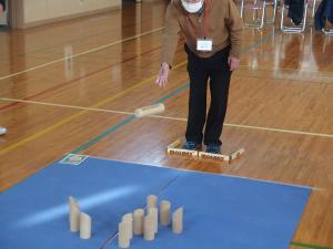 木の棒を投げ、ピンを倒して点数を積み重ねていきます