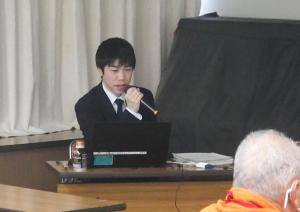 スライドを使用して講話する堤氏