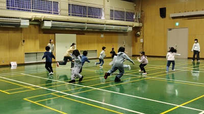 体育館でジュニアリーダーと小学生がいっしょに遊んでいる画像