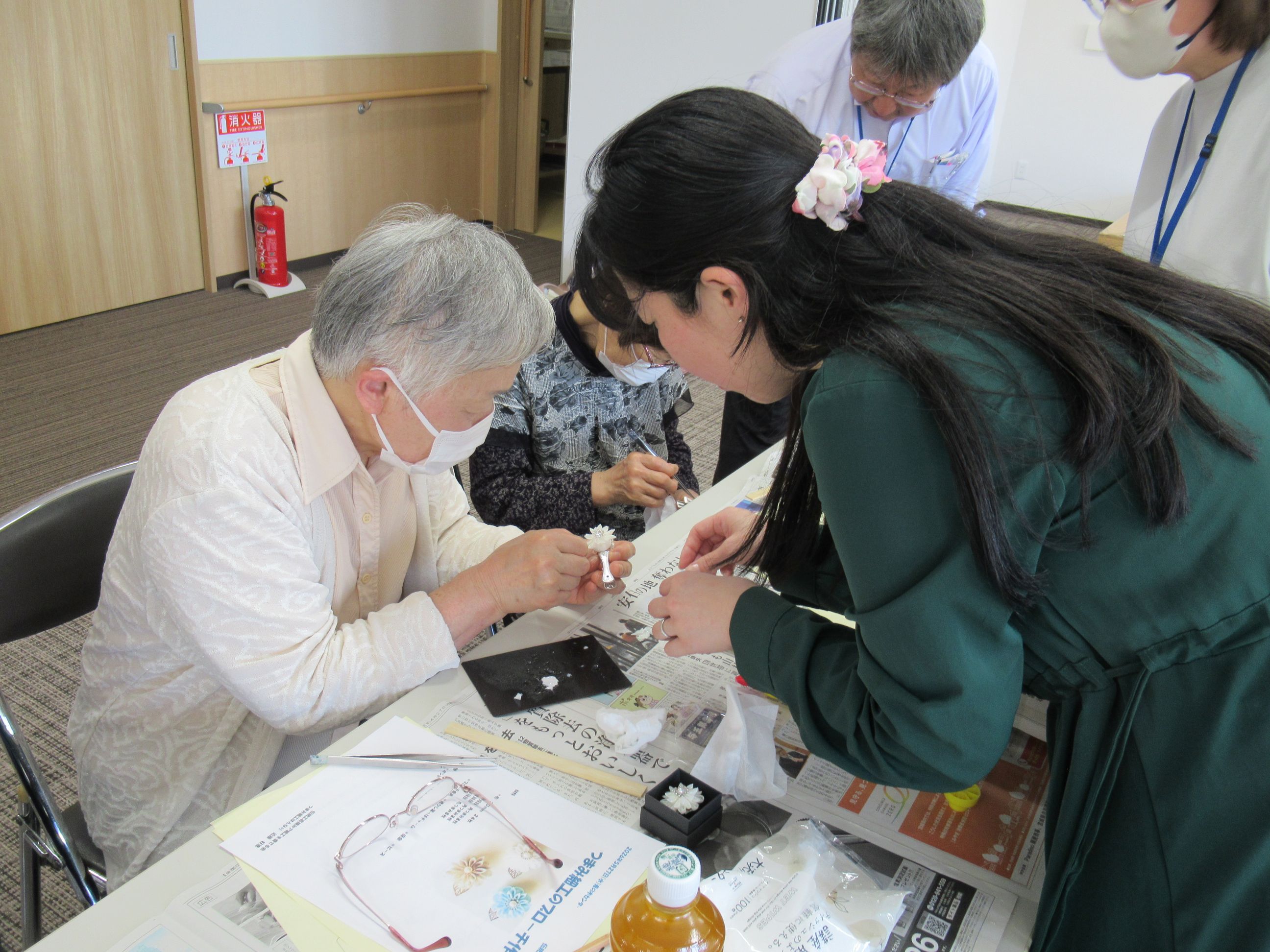 小さい布を丁寧に花びらの形につまんで、ブローチの台座にはりつけていきました。
